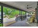 Inviting covered patio with wicker furniture and a ceiling fan overlooks the beautifully landscaped backyard at 742 Lansdowne Rd, Charlotte, NC 28270
