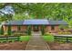 Charming brick home with a metal roof and beautifully landscaped front yard at 742 Lansdowne Rd, Charlotte, NC 28270