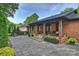 Inviting brick home porch featuring stone pavers, wood columns, and stylish decor at 742 Lansdowne Rd, Charlotte, NC 28270