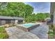 Modern pool surrounded by a stone patio, complemented by lush landscaping at 742 Lansdowne Rd, Charlotte, NC 28270