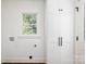 Laundry room with built-in storage cabinets and a window, with washer and dryer hookups at 754 Wriston Pl, Charlotte, NC 28209