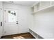 Bright mudroom features a storage bench with shelving, white cabinets, and door to the home's exterior at 754 Wriston Pl, Charlotte, NC 28209