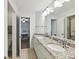 Bathroom with double sink vanity, granite countertops, and views to bedrooms at 7809 Greenfield Dr, Charlotte, NC 28270