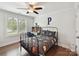 Well-lit bedroom with a ceiling fan, dark wood floors, and a large window at 7809 Greenfield Dr, Charlotte, NC 28270