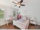 Well-lit bedroom with dark wood floors, a ceiling fan, and a work desk at 7809 Greenfield Dr, Charlotte, NC 28270