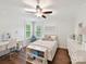Bright bedroom featuring hardwood floors, a ceiling fan, and neutral decor at 7809 Greenfield Dr, Charlotte, NC 28270