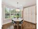 Sunny breakfast nook with large windows, built-in storage, and a round table with colorful chairs at 7809 Greenfield Dr, Charlotte, NC 28270