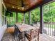 Enjoy outdoor dining on the covered patio with a wood ceiling, fan, stone floors, and views of the landscaped backyard at 7809 Greenfield Dr, Charlotte, NC 28270