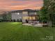 Rear exterior of a beautiful home featuring outdoor patio, entertainment areas, and a sprawling lawn with mature trees at 7809 Greenfield Dr, Charlotte, NC 28270