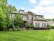 Beautiful two-story home showcasing stone accents, dormer windows, professional landscaping, and a well-manicured front lawn at 7809 Greenfield Dr, Charlotte, NC 28270