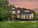 Beautiful two-story home showcasing stone accents, dormer windows, professional landscaping, and a well-manicured front lawn at 7809 Greenfield Dr, Charlotte, NC 28270