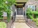 Charming front entryway featuring stone steps, dark wood door with sidelights, and manicured landscaping at 7809 Greenfield Dr, Charlotte, NC 28270