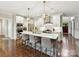 Well-lit kitchen boasts an island with barstool seating and modern light fixtures above at 7809 Greenfield Dr, Charlotte, NC 28270