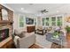 Inviting living room with stone fireplace, large windows, plush seating, and hardwood floors at 7809 Greenfield Dr, Charlotte, NC 28270