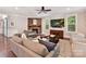 Cozy living room featuring a stone fireplace, hardwood floors, comfortable seating, and bright windows at 7809 Greenfield Dr, Charlotte, NC 28270