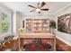 Bright office featuring custom shelving, hardwood floors, a wooden desk, and a ceiling fan at 7809 Greenfield Dr, Charlotte, NC 28270