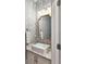 Stylish powder room with floral wallpaper, elegant mirror, and a modern sink at 7809 Greenfield Dr, Charlotte, NC 28270