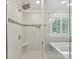 Modern shower with glass enclosure, a built-in seat, and white tiling at 7809 Greenfield Dr, Charlotte, NC 28270