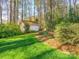 View of backyard with shed surrounded by lush green grass and mature trees offering shade and privacy at 8801 Chinaberry Ln, Concord, NC 28027