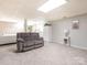 Basement space with neutral carpeting, a gray sofa, a bed, and a white storage cabinet at 8801 Chinaberry Ln, Concord, NC 28027
