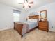 Comfortable bedroom with wood furniture, neutral carpeting, and natural light from the window at 8801 Chinaberry Ln, Concord, NC 28027