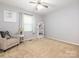 Cozy bedroom with neutral carpeting, chair, and furniture accents, with soft natural light at 8801 Chinaberry Ln, Concord, NC 28027
