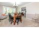 Bright dining room featuring a wooden table, elegant chandelier, and backyard view at 8801 Chinaberry Ln, Concord, NC 28027