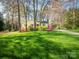 Charming single-story home with well-manicured lawn, mature trees and colorful landscaping creates lovely curb appeal at 8801 Chinaberry Ln, Concord, NC 28027