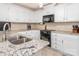 Well-lit kitchen with white cabinets, granite countertops, and modern appliances at 8801 Chinaberry Ln, Concord, NC 28027