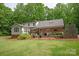 Rear exterior view of home with brick and siding, landscaping, and stone fireplace feature at 9941 Heritage Oak Ln, Waxhaw, NC 28173