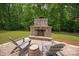 A stone outdoor fireplace with seating and a barrel table at 9941 Heritage Oak Ln, Waxhaw, NC 28173