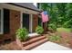 Inviting front porch with brick steps, decorative ferns, and a patriotic American flag at 9941 Heritage Oak Ln, Waxhaw, NC 28173