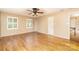 Neutral bedroom showcasing hardwood flooring, a ceiling fan, and a glimpse of the home's interior at 1000 Rudd Rd, Gastonia, NC 28054