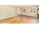 Bright living room with hardwood floors, a stone fireplace, and plantation shutters at 1000 Rudd Rd, Gastonia, NC 28054