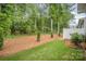 Landscaped backyard with a mix of lawn, mulch, and trees, creating a serene outdoor space at 10528 Audubon Ridge Dr, Cornelius, NC 28031