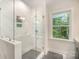 Bathroom featuring a glass-enclosed shower and a window, showcasing clean lines and modern design at 10528 Audubon Ridge Dr, Cornelius, NC 28031