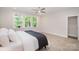 Bedroom featuring large window for natural light, complemented by stylish decor and a ceiling fan at 10528 Audubon Ridge Dr, Cornelius, NC 28031