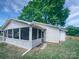 Back view showing a screened-in porch and mature tree at 109 Downing St, Troutman, NC 28166