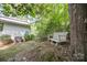 A tranquil backyard features a wooden bench, landscaping, and a glimpse of the home's exterior at 114 Walnut Creek Rd # 24, Belmont, NC 28012