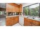 Kitchen with wooden cabinets, white appliances, and a pass-through window to the living room at 114 Walnut Creek Rd # 24, Belmont, NC 28012