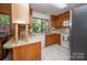 Cozy kitchen with wooden cabinets, white appliances, and a large window overlooking the outdoors at 114 Walnut Creek Rd # 24, Belmont, NC 28012