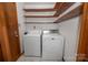 Laundry room featuring wooden shelving, white washer and dryer, and a wood door at 114 Walnut Creek Rd # 24, Belmont, NC 28012