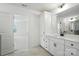 Bright bathroom featuring white cabinets, a double sink, and an open door to the bedroom at 119 Longwood Rd # 62, Mooresville, NC 28115