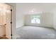 Spacious bedroom with neutral carpet, a large window and an en-suite bathroom at 119 Longwood Rd # 62, Mooresville, NC 28115