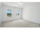 Bright bedroom with natural light from windows, access to a balcony, and neutral carpeting at 119 Longwood Rd # 62, Mooresville, NC 28115