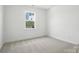 Bedroom with neutral carpet, window view to a backyard, and minimal design at 119 Longwood Rd # 62, Mooresville, NC 28115