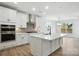 Bright kitchen featuring an island, stainless appliances, and hardwood floors at 119 Longwood Rd # 62, Mooresville, NC 28115