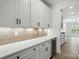Kitchen area with white cabinetry, stainless steel wine cooler, and a subway tile backsplash at 119 Longwood Rd # 62, Mooresville, NC 28115