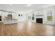 Open-concept kitchen and living space with fireplace, stainless hood, and hardwood floors at 119 Longwood Rd # 62, Mooresville, NC 28115