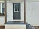 Close up view of front door with wreath, gray steps and dark wooden posts, fresh exterior paint at 13131 601 S Hwy, Midland, NC 28107
